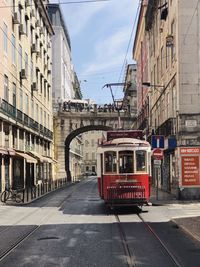 Cable car on railroad tracks amidst buildings in city