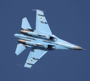 Low angle view of airplane flying against clear blue sky