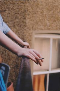 Midsection of woman smoking cigarette