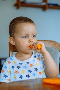 Portrait of cute boy eating food at home