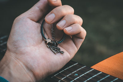 Cropped hand holding bracelet