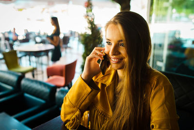 Portrait of smiling young woman using mobile phone