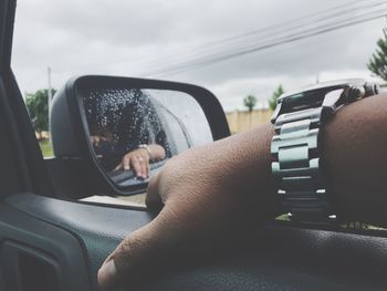 Cropped hand of man in car