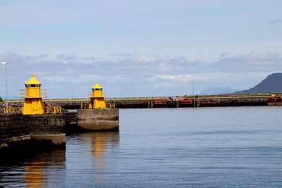 Bridge over sea against buildings