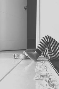 Low section of woman lying on floor at home