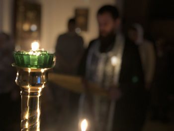 Close-up of lit candles on glass