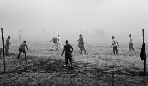 Group of people walking on land against sky