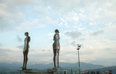 View of woman standing against cloudy sky