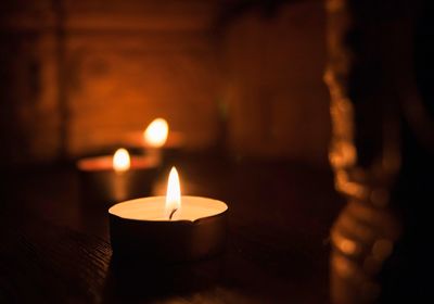 Close-up of lit tea light candles in temple