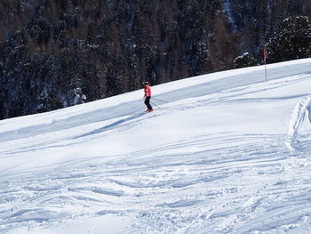 Side view of person skiing on snow covered field