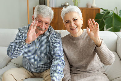 Portrait of senior couple sitting on bed at home