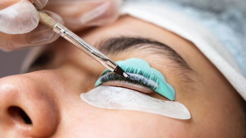 Close-up of woman applying nail