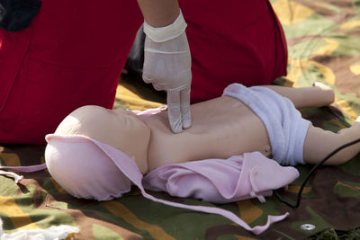 Midsection of paramedic performing cpr on dummy