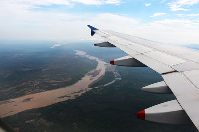 Airplane flying over landscape against sky