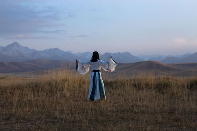 Rear view of woman standing on mountain