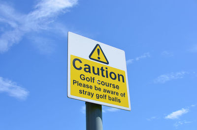 Low angle view of information sign against blue sky