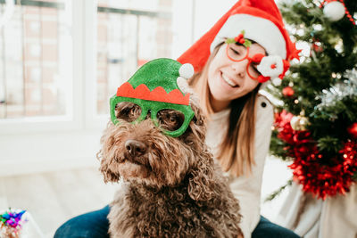 Full length of dog with hat on christmas tree