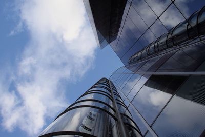 Low angle view of modern building against cloudy sky