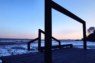 Pier on sea at sunset