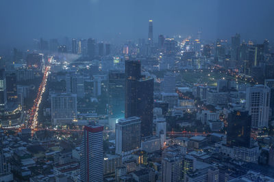 High angle view of illuminated cityscape against sky at night