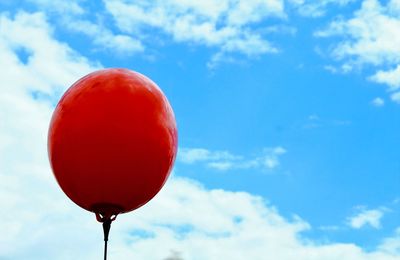 Low angle view of red balloon against sky