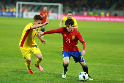 Men playing soccer on field