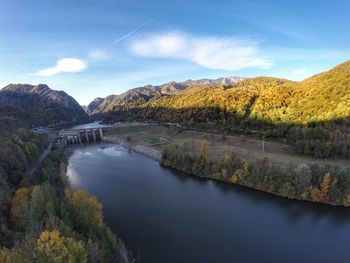 Scenic view of river and mountains against sky