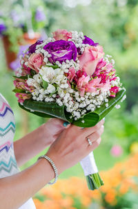 Midsection of woman holding bouquet of flowering plant