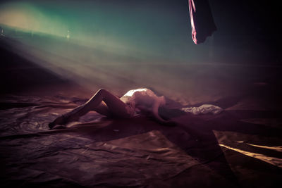 Low section of woman resting on bed