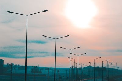 Low angle view of street lights against sky during sunset