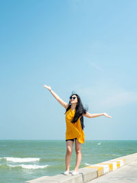 Full length of young woman standing on beach