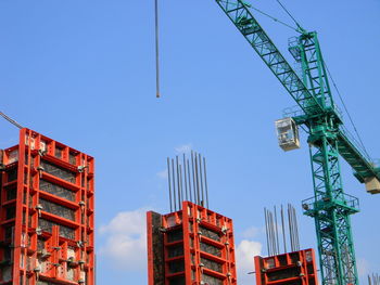 Low angle view of crane against clear blue sky