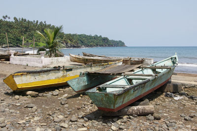 Boats moored at shore against clear sky