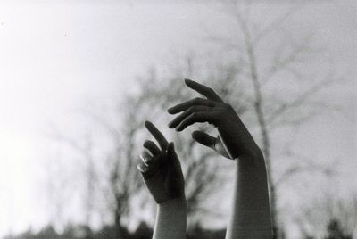 Cropped hand of person against sky