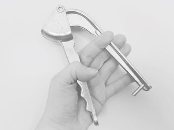 Close-up of hand holding ring over white background