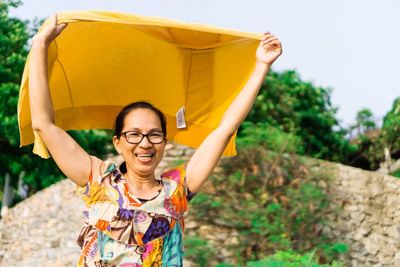 Smiling woman looking away while holding fabric 