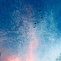 Low angle view of airplane flying against blue sky