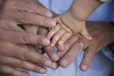 High angle view of people stacking hands