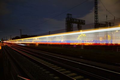 Light trails on railroad station platform at night