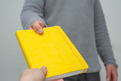 Close-up of hand holding yellow paper