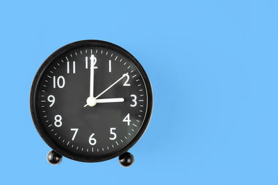 Close-up of clock tower against blue background