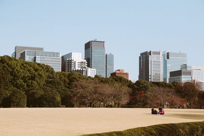 Buildings in city against clear sky