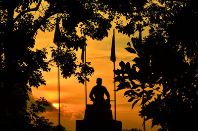 Low angle view of silhouette statue against sky during sunset