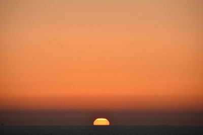 Scenic view of sea against orange sky