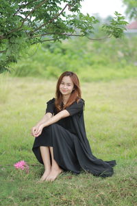 Portrait of woman sitting on field