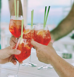 Close-up of hands holding cocktail glasses