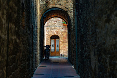 Man walking in alley amidst buildings