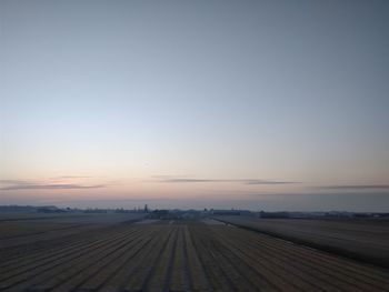 Scenic view of landscape against clear sky during sunset