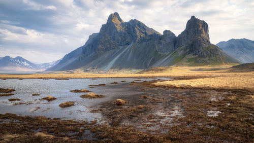 Scenic view of lake by mountains against sky