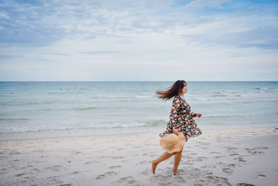 Full length of woman at beach against sky